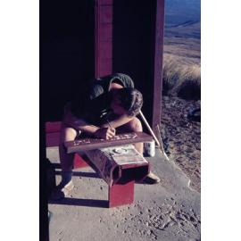 Painting the Ketetahi Hut sign: Tongariro National Park