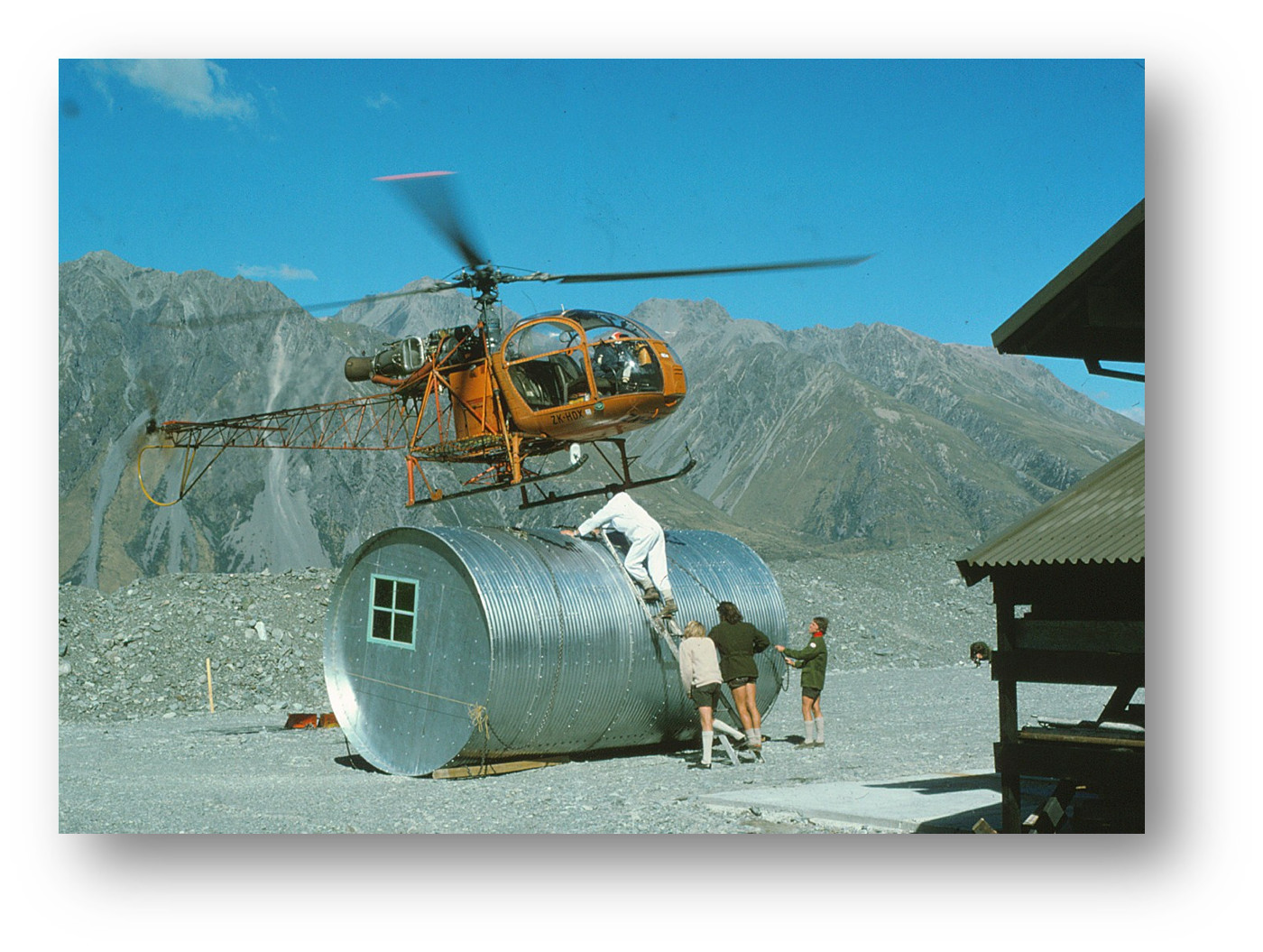 Helicopter hovering over Gardiner Hut in the yard.
